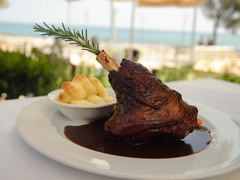 A plated dish at Di Capilla with a seaside view